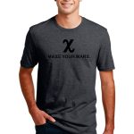 Smiling man wearing a dark gray T-shirt with the text "MAKE YOUR MARX" and a stylized "X" above it. He has short dark hair and is standing casually with one hand in his pocket against a plain white background.