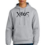 Person wearing a gray hoodie with a unique black design printed on the front. The individual has short, light-colored hair and is standing against a plain white background. The hoodie has a front pocket and drawstrings.