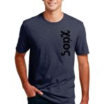 Smiling person wearing a dark blue t-shirt with the word "Sodx" printed vertically on the front. The person has short, dark hair and is standing with one hand in their blue jeans pocket against a plain white background.