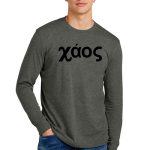 Young man in a gray long-sleeve shirt with the word "χάος" printed in black on the front. He is standing with one hand in his pocket, wearing blue jeans, against a plain white background.